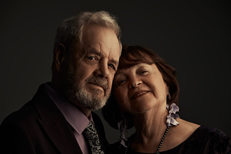 Love and affection. A happy elderly married couple in fashionable evening dresses tenderly hug each...