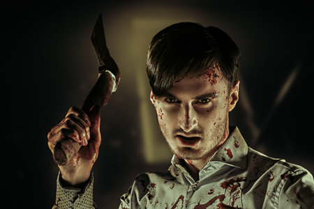 Horror, thriller. A brutal killer maniac, covered in blood, swings an ax at his victim in a fit of...