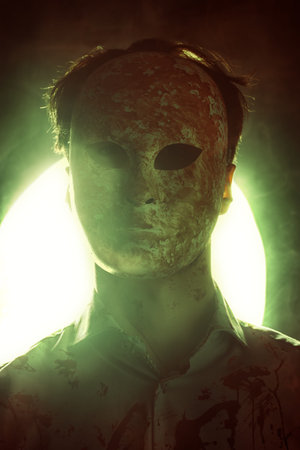 Thriller, horror. A psychopathic maniac, splattered with blood, hides his face under a bloodied...