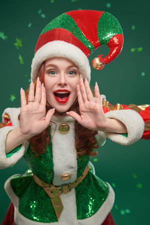 Tales for Christmas and New Year. Studio portrait of a merry beautiful Christmas fairy elf girl in a...