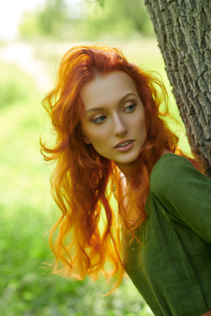 Celtic culture. Fantasy world. Portrait of a beautiful red-haired girl of the Middle Ages walking in the dense forest.の写真素材