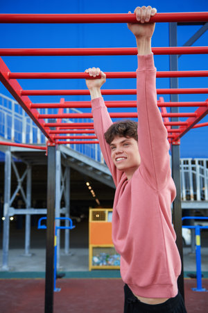 Sports and outdoor activities. A handsome young man is exercising on a street sports ground near a shopping mall. Urban lifestyle.の写真素材