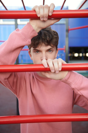A handsome young man is on a street sports ground near a shopping mall. Urban lifestyle. Sports and outdoor activities.の写真素材