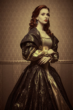 Retro style portrait of a beautiful red-haired princess in a puffy brown and gold dress on a vintage background. Fairytale heroine. Tales of princesses.の写真素材