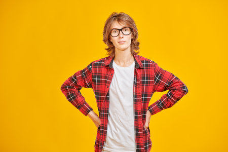 A high school student boy shows happiness and smiles. Modern lifestyle, education. Yellow studio background. Place for text.の写真素材