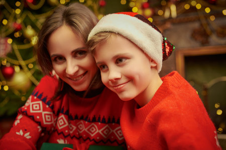 A happy mother and her child boy are rejoicing on Christmas night at home. Magic atmosphere is around. Family Christmas and New Year.の写真素材
