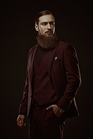 Fashion and style for men. Handsome well-groomed mature man posing in an elegant three-piece suit on a black studio background. Business style.の写真素材