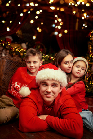 Family Christmas and New Year celebration. A happy family of parents and two children lying near the Christmas tree and smiling.の写真素材