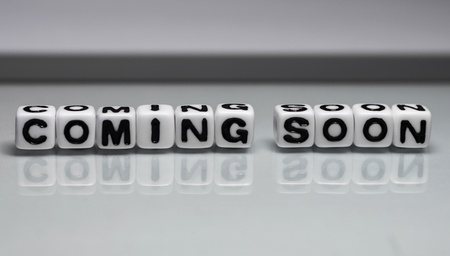 Coming soon message on glass sheet which is relectin the letters  の写真素材