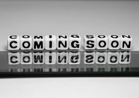 Coming soon message on glass sheet and its reflection along with shadow on matching background の写真素材