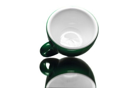 Empty green cup on reflective surface and white background  の写真素材
