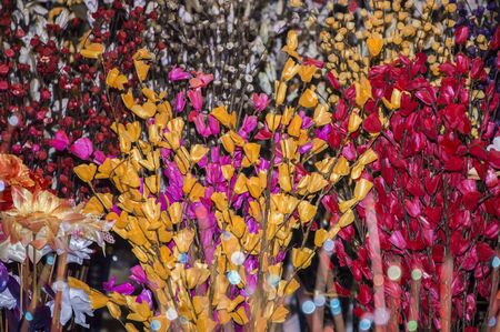 Artificial fabric flowers of different colors on sale.の写真素材