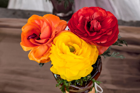 Artificial flowers in vase on the base.