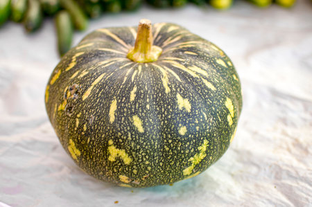 Green and yellow pumpkin on ground for saleの写真素材