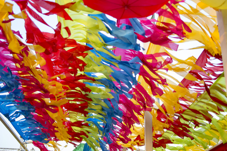 Multicolored papers decorating sky over streetの写真素材