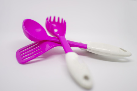 Shiny pink spoon and spatula with flipper on top of each other.の写真素材