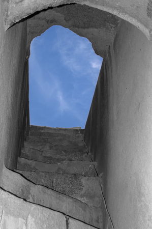 Stairs leading to open sky from dark pathの写真素材