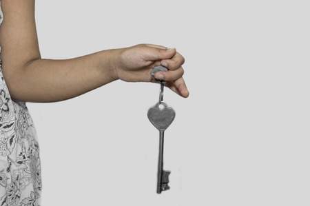 A women holds the key in her hand on white surfaceの写真素材