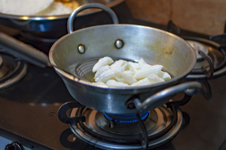 Frying snacks indian way in hot oil and pan an don fireの写真素材