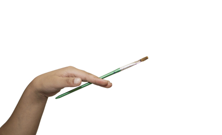 Painting brush in fingers of a girl on whiteの写真素材
