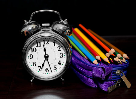 School pencils with alarm clock and other boxes for back to school concept on table