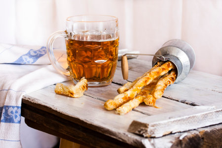 Cheese stick cracker with sesame seeds and beer