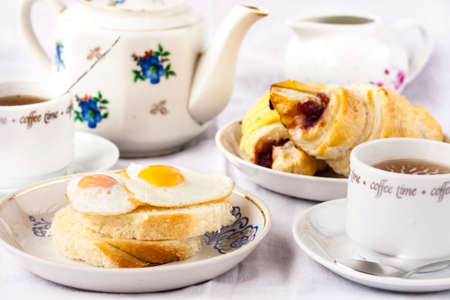 Breakfast with croissants, quail eggs and teaの写真素材