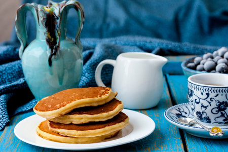 Stack of pancakes on vintage white wooden background