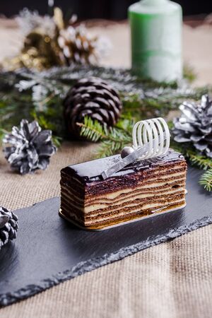 chocolate honey cake  on a black plate and Christmas backgroundの写真素材