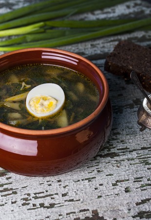 Nettle soup with eggs in the bowl on the tableの写真素材
