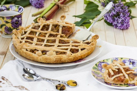 homemade tart with rhubarb and strawberries on the tableの写真素材