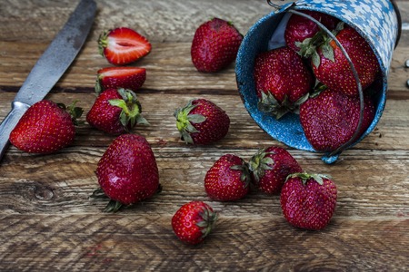 Strawberry in a small bucket on the wooden boardの写真素材