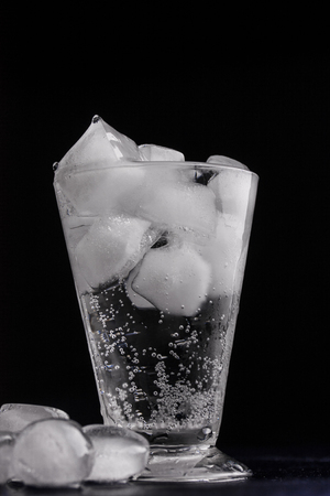 glass of water with ice on black backgroundの写真素材