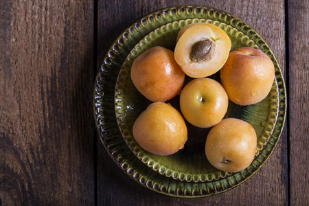 Fresh orange apricots on the dark wooden tableの写真素材