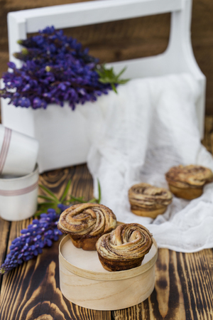 Cruffins - buns from yeast dough in powdered sugar on wooden backgroundの写真素材