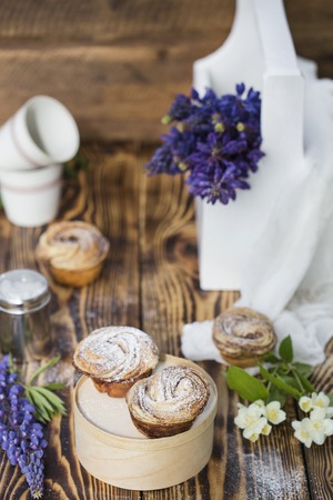 Cruffins - buns from yeast dough in powdered sugar on wooden backgroundの写真素材