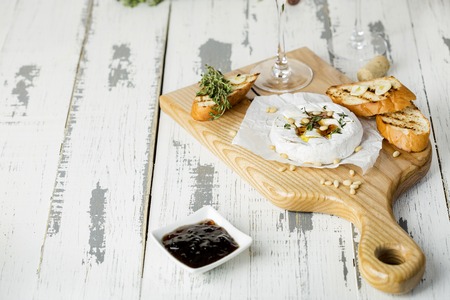 Baked camembert with toasts and thyme on rustic wooden tableの写真素材