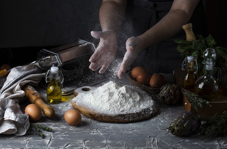 Female hands making pasta dark rustic styleの写真素材