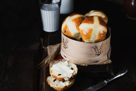 classic English Easter hot cross buns with dried fruits on vintage background