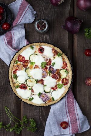 Homemade zucchini and cherry tomato tart with mozzarellaの写真素材