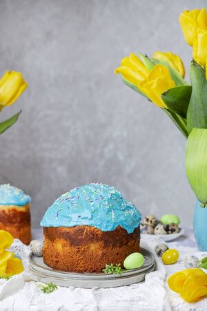 Traditional easter cake on the table with bouquets of tulipsの写真素材