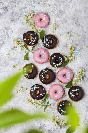 Delicious glazed doughnuts on white background and flowersの写真素材