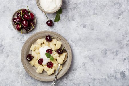 Russian cottage cheese dumplings with sour cream and cherriesの写真素材