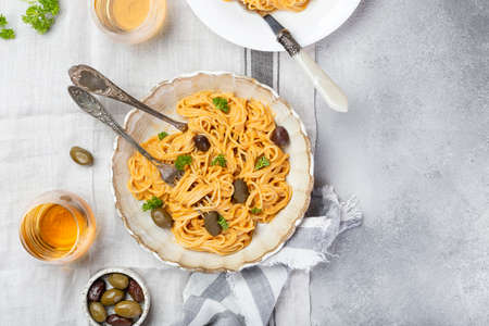 spaghetti in creamy tomato sauce with olivesの写真素材
