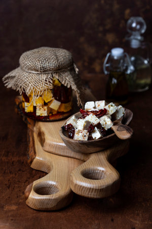 pickled feta cheese with herbs and sun-dried tomatoes in olive oilの写真素材