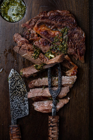 Slices of beef steak on dark wooden board