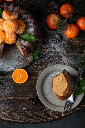 Homemade Citrus Tangerine cake decorated with powdered sugar and mandarin on wooden table backgroundの写真素材
