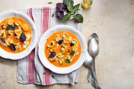 tomato soup with cappelletti pasta, cream and basilの写真素材
