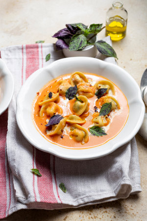 tomato soup with cappelletti pasta, cream and basilの写真素材