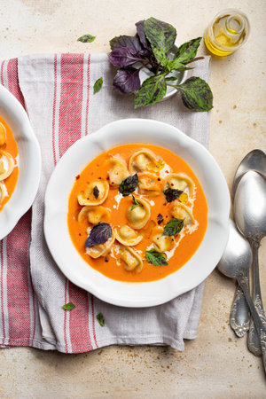 tomato soup with cappelletti pasta, cream and basilの写真素材